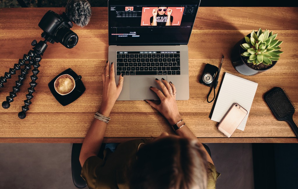 woman working on computer with camera on table