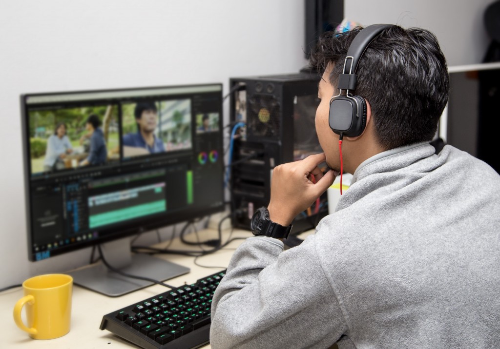 man wearing headphones and editing a video